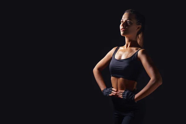 Sexy athletic fitness woman. Black background