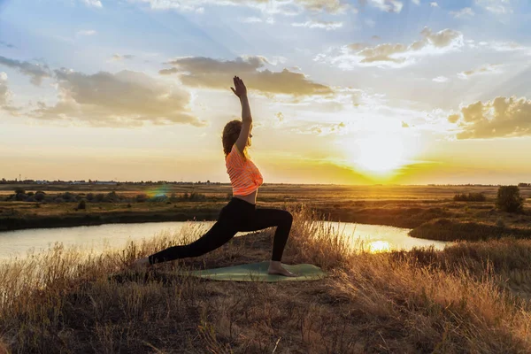 Genç sarışın kadın dışarıda yoga yapıyor.. 