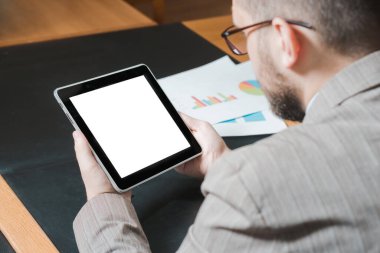 Gözlüklü genç işadamı kişisel ofisinde tablet üzerinde çalışıyor. Model.