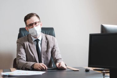 Gözlüklü ve maske takan genç işadamının portresi. Karantina sırasında iş.