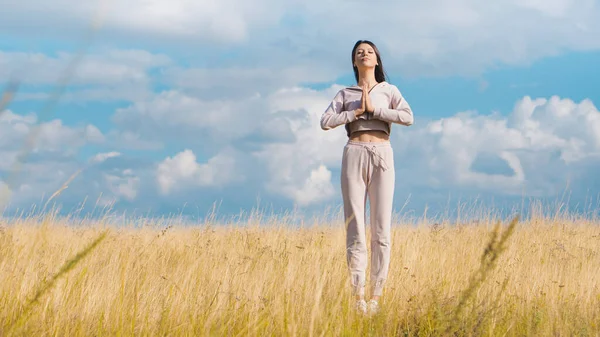 Sarı tarlada yoga yapan hoş bir kadın. Bakım kavramı