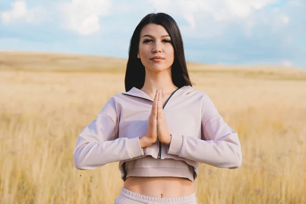 Sarı tarlada yoga yapan hoş bir kadın. Bakım kavramı