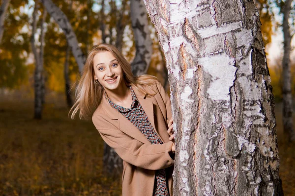 Junge Schöne Lächelnde Frau Langen Mantel Lugt Hinter Einem Baum — Stockfoto