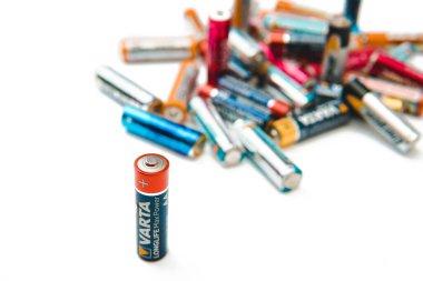 KAZAKHSTAN-OCTOBER 5, 2020: Beyaz zemin üzerinde yığınla kullanılmış pil ve VARTA bataryası. İzole edilmiş.
