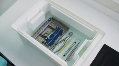 Bir teknisyenin elleri kutuyu diş aletleriyle kapatır.