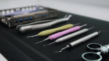 Siyah paspasın üzerindeki dişçi aletlerinin yan görüntüsü. Diş aracının kenarına odaklan