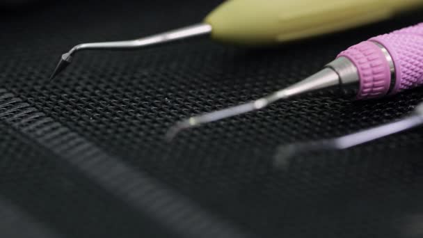 Close-up shot van Tandartsgereedschap op zwarte mat. Racking focus aan de rand van de tandheelkundige tool — Stockvideo