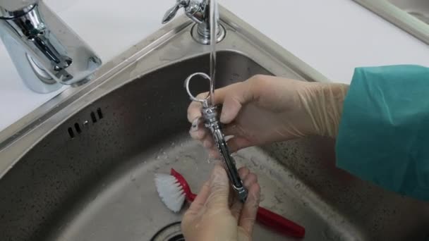 Zbliżenie rąk pielęgniarki myć narzędzia stomatologiczne pod strumieniem wody destylowanej — Wideo stockowe