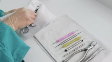 Laboratuvar teknisyenlerinin eldiven içindeki elleri diş şırıngasını siliyor.