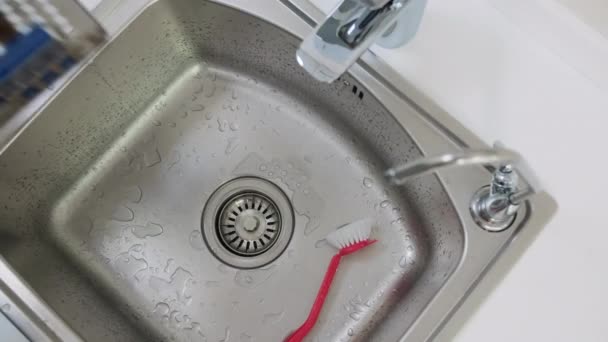 Tiro de alto ângulo de mãos de médicos coloca uma bandeja de ferramentas dentárias na pia e lavar — Vídeo de Stock