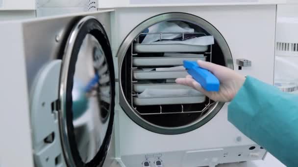 Técnico diseñar el paquete con herramientas dentales de autoclave después de la desinfección — Vídeo de stock