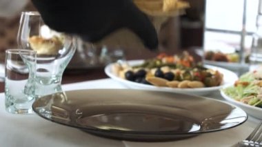 Garson bir sepet Pita ekmeğine Yunan salatası koyar, yakın plan.