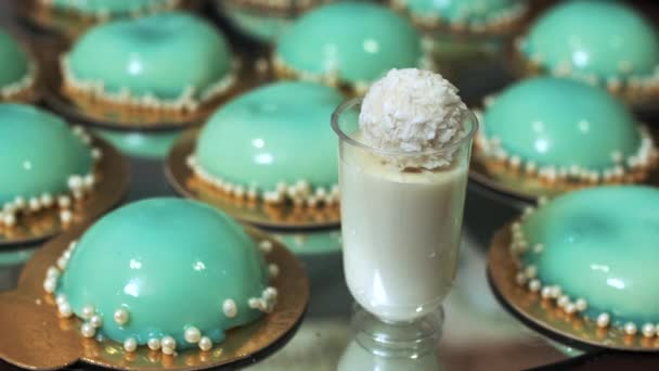 Sobremesa branca com barracas de coco em um fundo de cupcakes turquesa — Vídeo de Stock