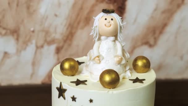 Egy fehér torta, csillagokkal díszítve, és egy angyal alakja, közeli nyomkövető lövés. — Stock videók