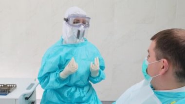 Kadın bir dişçiye danışıyorum. Hasta dikkatle doktoru dinliyor.