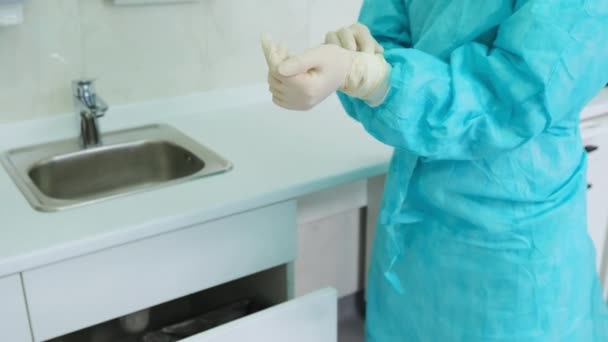 Tandläkaren assistent tar bort översta par av skyddande vita handskar — Stockvideo