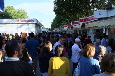Madrid / İspanya; 03 / 06 / 2018. Madrid 'de kitap fuarı. İnsanlar Retiro parkında tezgahların arasında yürüyor. Satıcılar ve alıcılar bazı yazarlarla kitap ithaf ediyorlar. Kitap fuarı Madrid 25 Mayıs 'tan 10 Haziran' a kadar.