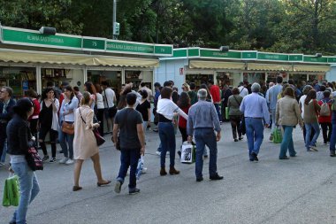 Madrid / İspanya; 03 / 06 / 2018. Madrid 'de kitap fuarı. İnsanlar Retiro parkında tezgahların arasında yürüyor. Satıcılar ve alıcılar bazı yazarlarla kitap ithaf ediyorlar. Kitap fuarı Madrid 25 Mayıs 'tan 10 Haziran' a kadar.