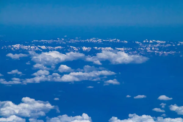 The snowy Pyrenees and clouds on its southern side. View ot the mountain range from a commercial flight from the province of Zaragoza.