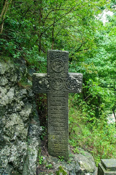 Cross next to the Chapel of the Heart of Queen Mary. Stone Christian cross with religious motifs located near Bran Castle in Romania.