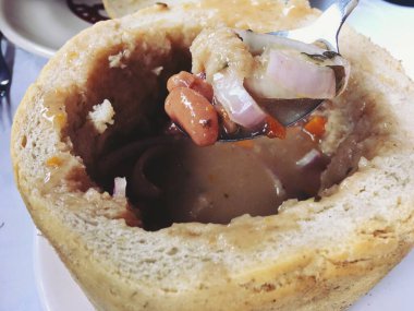 Fasulye çorbası. Romanya 'nın batısındaki Ciorba de Fasole' den geleneksel yemek. Sighisoara, Transilvanya 'da bir restoranda içi boş bir somun ekmeğin içinde bir tabak olarak sunuldu..