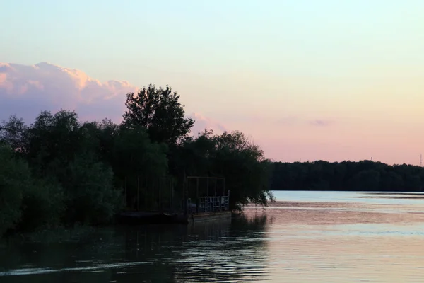 ドナウ川の岸に係留されていた古い船のシルエット ルーマニアのヌファルを通過する日没時のドナウデルタ — ストック写真