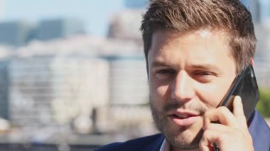 Cep telefonunuzun ve yavaş arka planda şehir manzarası ile işadamı