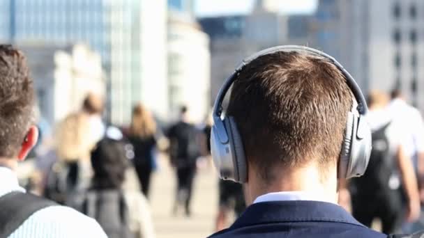 Οπίσθια Όψη Του Επιχειρηματία Φορώντας Ασύρματα Ακουστικά Περπάτημα Στην Εργασία — Αρχείο Βίντεο