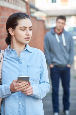 Genç kadın manifatura için yardım etmek üstünde hareket eden şehir sokak üzerinde takip ederken telefon