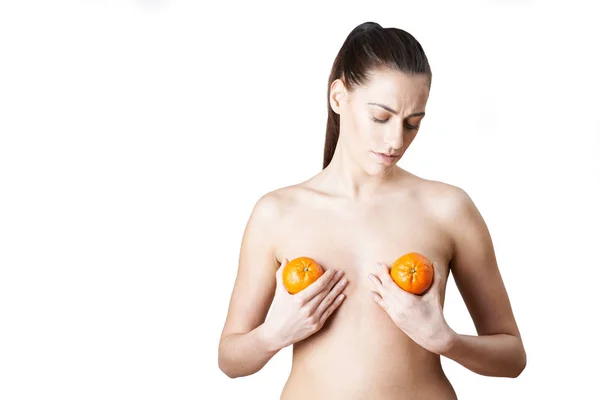 妇女手持无核小蜜橘说明乳房扩大手术 — 图库照片