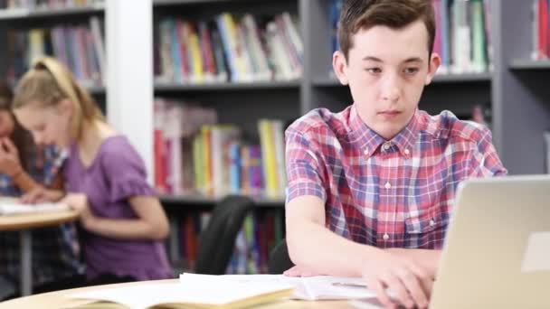 Estudiante Masculino Secundaria Trabajando Ordenador Portátil Biblioteca — Vídeo de stock