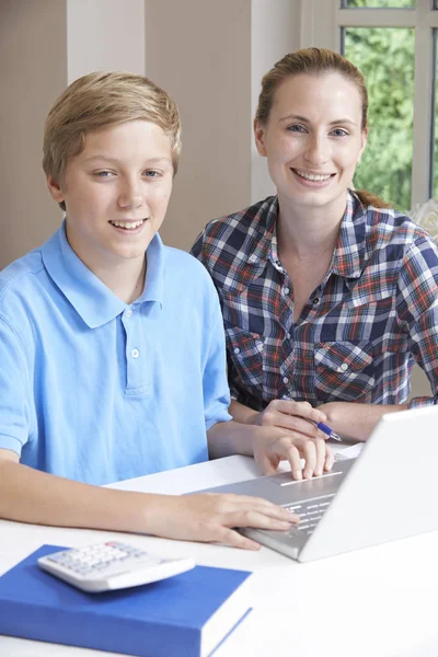女家庭导师的肖像帮助男孩用笔记本电脑学习 — 图库照片