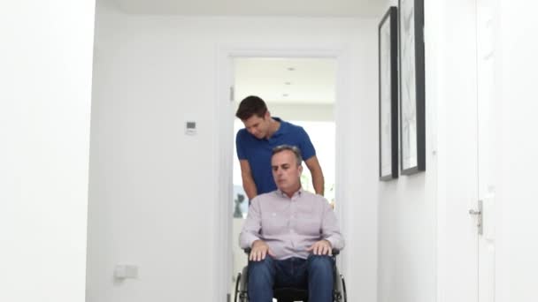 Portret Opiekunem Pchanie Dojrzały Mężczyzna Domu Pomocą Wózka Inwalidzkiego — Wideo stockowe