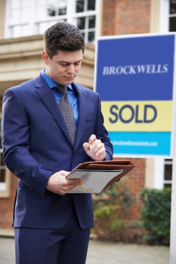 Erkek Emlak dış konut emlak satıldı işareti ile ayakta