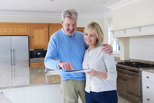 Oudere Paar Nieuwe Woning Permanent Keuken Kijken Naar Brochure Bekijken — Stockfoto