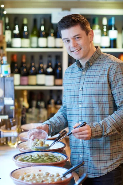 Portret Van Mannelijke Klant Delicatessen Vullen Pot Met Groene Olijven — Stockfoto