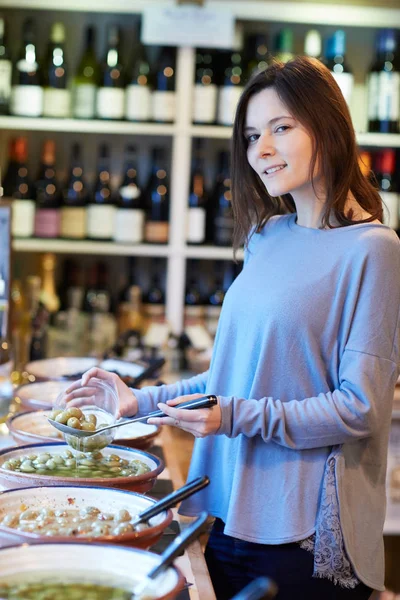Porträtt Kvinnlig Kund Delikatessbutik Fylla Krukan Med Gröna Oliver — Stockfoto
