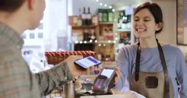 Erkek müşteri istimal hareket eden telefon içinde Şarküteri alışveriş için temassız ödeme yapmadan 