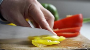 Doğrama Tahtası üzerinde bıçak ile Sarı Biber Dilimleme Adam Close Up