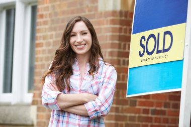 Satılan Tabela ile Yeni Ev Dışında Duran Gülümseyen Kadın