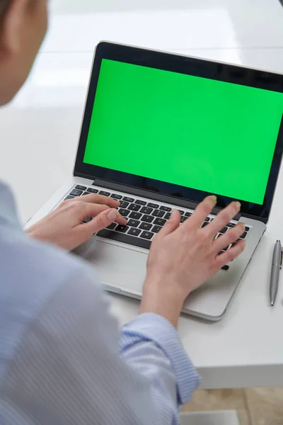 Over de schouder weergave van zakenvrouw met behulp van groen scherm Lapto — Stockfoto