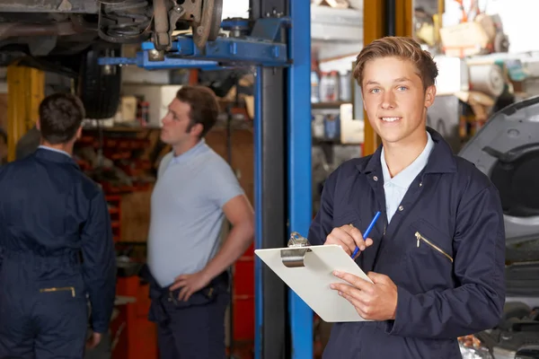 Portret Apprentice mechanik trzyma schowek praca w aut — Zdjęcie stockowe