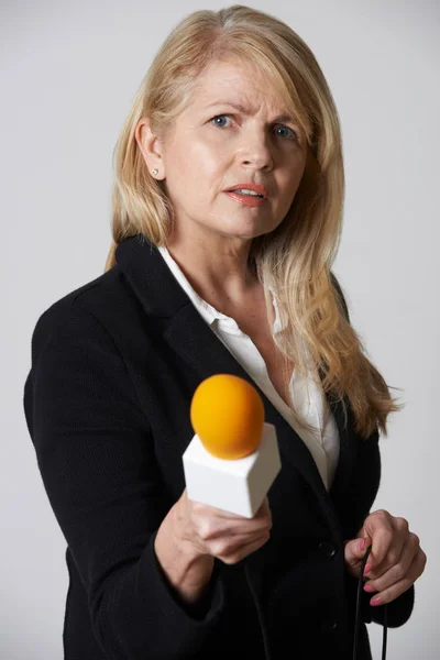 Jornalista feminina com microfone em fundo branco — Fotografia de Stock