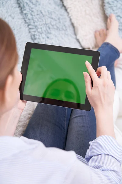 Sopra la spalla vista di donna sdraiata sul divano utilizzando lo schermo verde — Foto Stock
