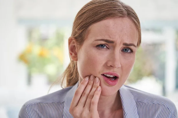 Portret młodej kobiety cierpiącej z Toothache dotykając szczęki — Zdjęcie stockowe