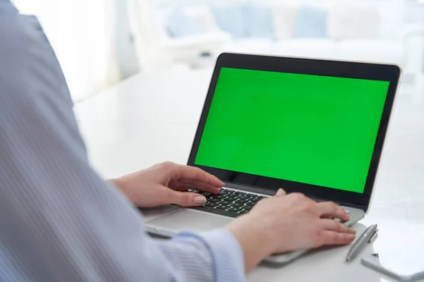 Over de schouder weergave van zakenvrouw met behulp van groen scherm Lapto — Stockfoto