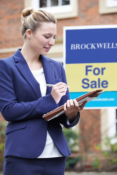 Femmina agente immobiliare in piedi prendere appunti al di fuori Residenziale Propert — Foto Stock