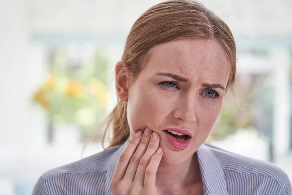 Jeune femme souffrant avec mal de dents touchant mâchoire — Photo