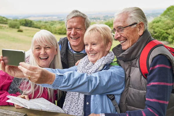Group Of Senior Friends Hiking In Countryside Standing By Gate — Stock Photo, Image
