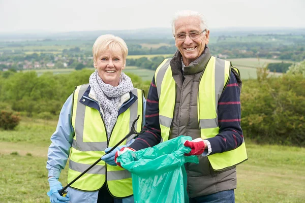 Portrait Of Helpful Senior Couple Collecting Litter In Countrysi — Stock Photo, Image